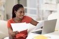 Black Woman Working With Papers And Laptop ComputerAt Home Office Royalty Free Stock Photo