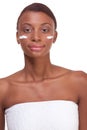 Black woman wrapped in towel moisturizing face Royalty Free Stock Photo