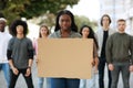 Black woman with empty placard leading group of protestors