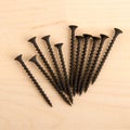 Black wood screws on wooden background. Royalty Free Stock Photo