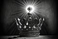 A black wood table with a silver metal king or queens crown on it