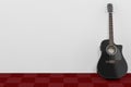 Black Wooden Acoustic Guitar in Room with Red Carpet Floor and W Royalty Free Stock Photo
