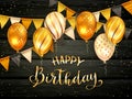 Golden Birthday Balloons and Pennants on Black Wooden Background Royalty Free Stock Photo