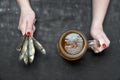 A woman holds a mug of cold beer and salted fish on a black wooden background. Royalty Free Stock Photo