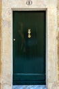 Black wooden door with brass vintage knocker as dolphin with a trident-shaped tail Royalty Free Stock Photo