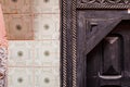 Black wooden door with tiled white wall decoration detail Royalty Free Stock Photo