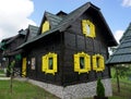 Black wooden house with yellow windows