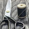 On a black wooden stench, close-up, scissors spool of thread wit