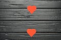 Black wooden textured background with red hearts. Royalty Free Stock Photo