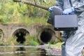 Black working suitcase and tablet in the hands of a specialist in working with toxic substances, on the background of treatment Royalty Free Stock Photo