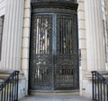 Black wrought iron door on the side of a building with a staircase leading up to it.