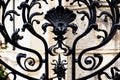 black wrought iron fence. forged steel decorative elements. soft blurred stucco old building elevation Royalty Free Stock Photo