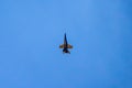 A black and yellow fighter jet performing aerial maneuvers solo