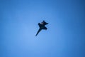 A black and yellow fighter jet performing aerial maneuvers solo