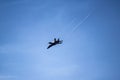 A black and yellow fighter jet performing aerial maneuvers solo