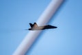 A black and yellow fighter jet performing aerial maneuvers solo