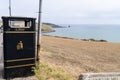 Black and yellow litter bin or garbage can at a coastal area in Great Brittain England south coast