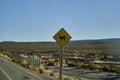 black and yellow road sign standing next to the street in Chile at the panamerican highway. Royalty Free Stock Photo