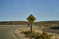 black and yellow road sign standing next to the street in Chile at the panamerican highway. Royalty Free Stock Photo
