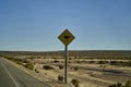 black and yellow road sign standing next to the street in Chile at the panamerican highway. Royalty Free Stock Photo