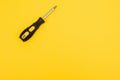 black and yellow screwdriveron a yellow background with space for text. Tools, construction and workshop, home repairs Royalty Free Stock Photo