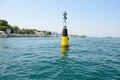 Black and yellow sea buoy bobs on the waves in the bay Royalty Free Stock Photo