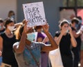 Black young girl holding a banner during demonstration against racism. Black lives matter message