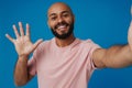 Black young man with beard waving hand while taking selfie photo Royalty Free Stock Photo