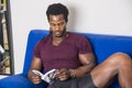 Black young man at home reading a book Royalty Free Stock Photo