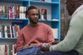 Black young man talking to therapist or guidance counsellor in college library Royalty Free Stock Photo