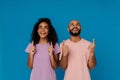 Black young man and woman laughing while pointing fingers upward Royalty Free Stock Photo