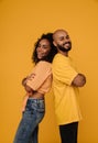 Black young man and woman smiling while standing back to back Royalty Free Stock Photo