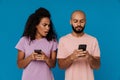 Black young man and woman using mobile phones together