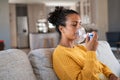 African american woman using nebulizer inhaler at home
