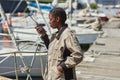 Black young woman holding portable radio working in yacht docks