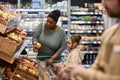 Black young woman with little girl shopping for groceries in supermarket Royalty Free Stock Photo