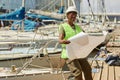 Black young woman looking at blueprints working in yacht docks