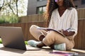 African young woman student learning using laptop studying outside campus. Royalty Free Stock Photo