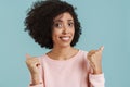 Black young woman smiling while pointing fingers away Royalty Free Stock Photo