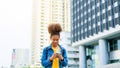 Black young woman, using smart phone and smile with walking in the city outdoor Royalty Free Stock Photo