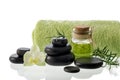 Black zen stones for hot massage with  oil bottle, towel, rosemary and orchid flower  isolated on white Royalty Free Stock Photo