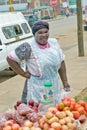 Black Zulu woman with tribal makeup on her face sells vegetables in Zulu village in Zululand, South Africa
