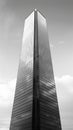 a black and white photo of a tall building against a cloudy sky Royalty Free Stock Photo