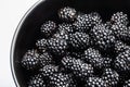 Blackberries in a black bowl, ripe fresh berries macro photo