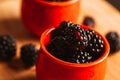 Blackberries in a cup on blurred background of wooden planks Royalty Free Stock Photo