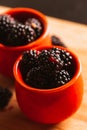 Blackberries in a cup on blurred background of wooden planks Royalty Free Stock Photo