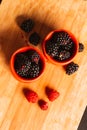 Blackberries in a cup on blurred background of wooden planks Royalty Free Stock Photo