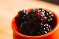 Blackberries in a cup on blurred background of wooden planks Royalty Free Stock Photo