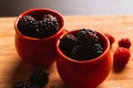 Blackberries in a cup on blurred background of wooden planks Royalty Free Stock Photo