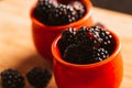 Blackberries in a cup on blurred background of wooden planks Royalty Free Stock Photo